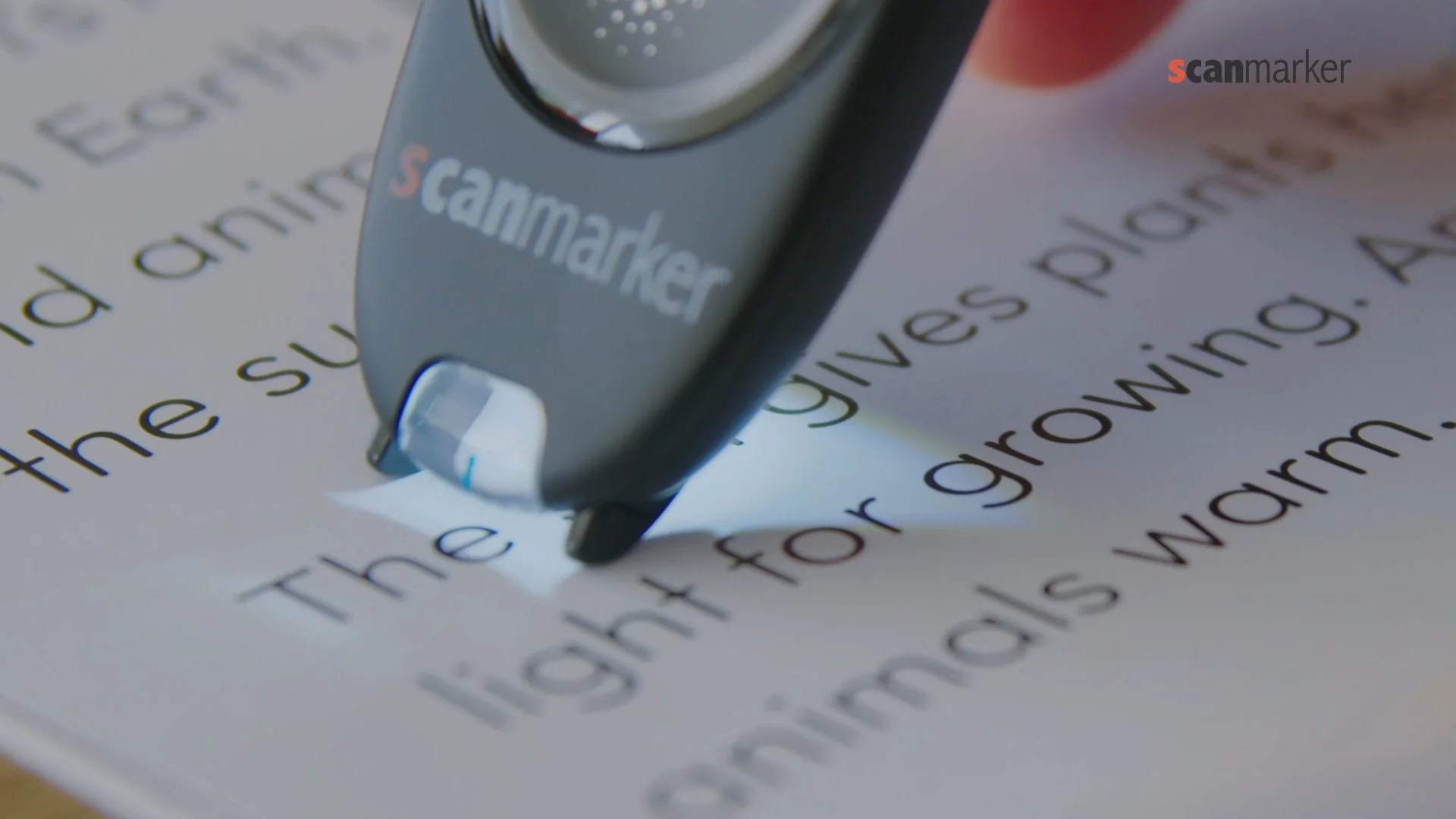 Close-up of a scan reader pen scanning a line of printed text on a page